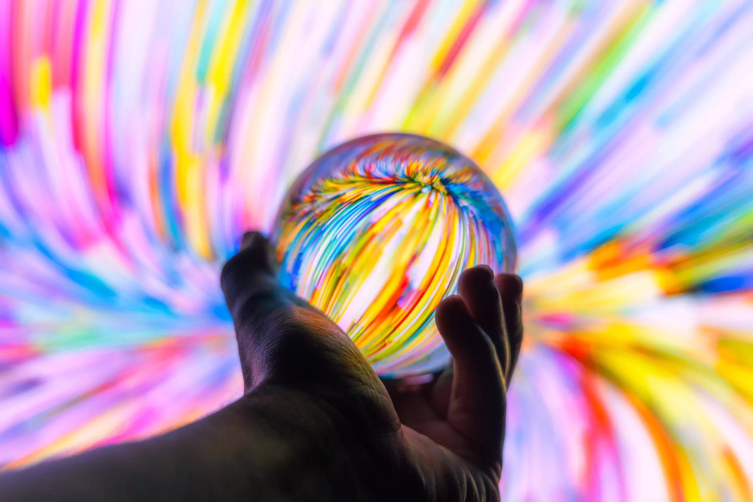 Holding a crystal ball through colorful background